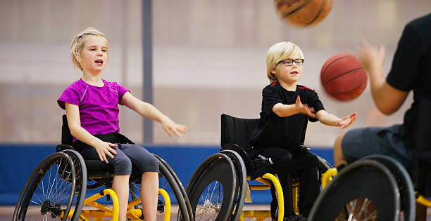 Des enfants en chaise roulante jouent au basket
