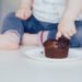 Un bébé met son doigt dans un gâteau au chocolat