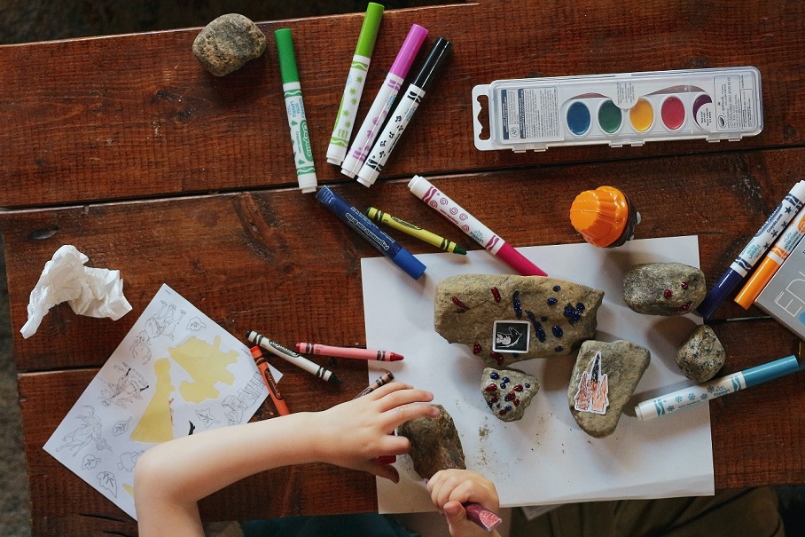 Un enfant fait une expérience avec des pierres et de la peinture