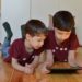 Deux petits garçons regardent quelque chose sur une tablette