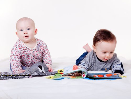 Deux bébés jouent avec un livre