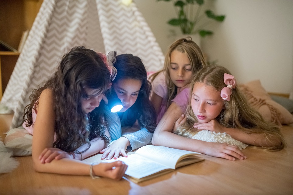 Des jeunes filles lisent un livre en cachette