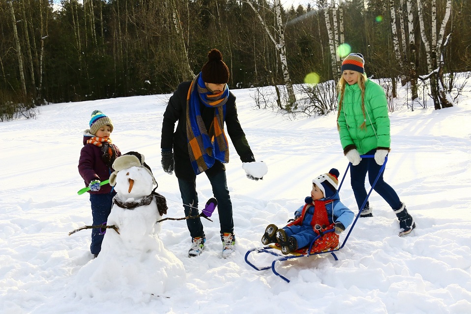 Une famille joue dans la neige