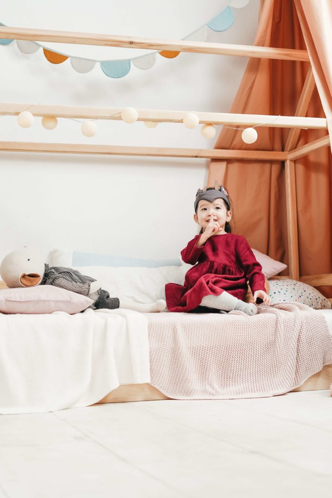 Une petite fille est installée dans son lit cabane