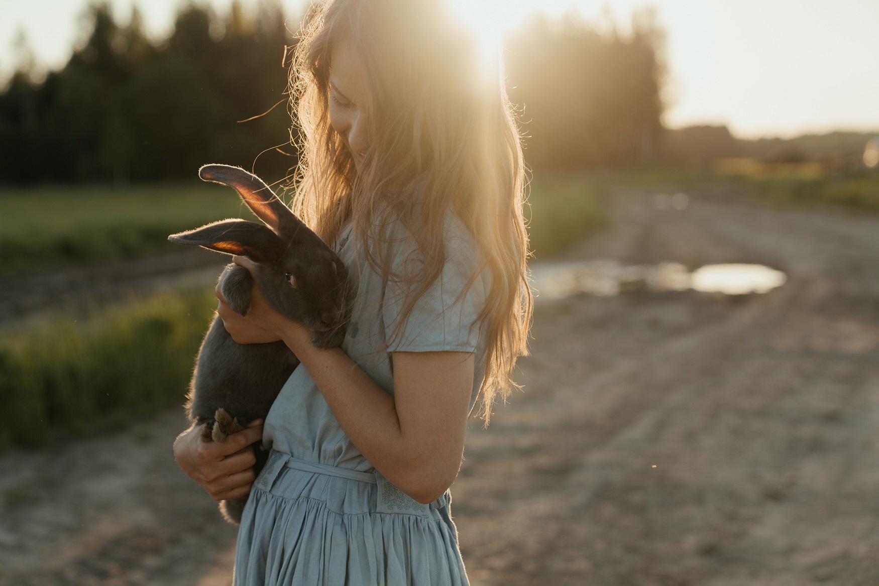 Une jeune femme porte un lapin dans ses bras
