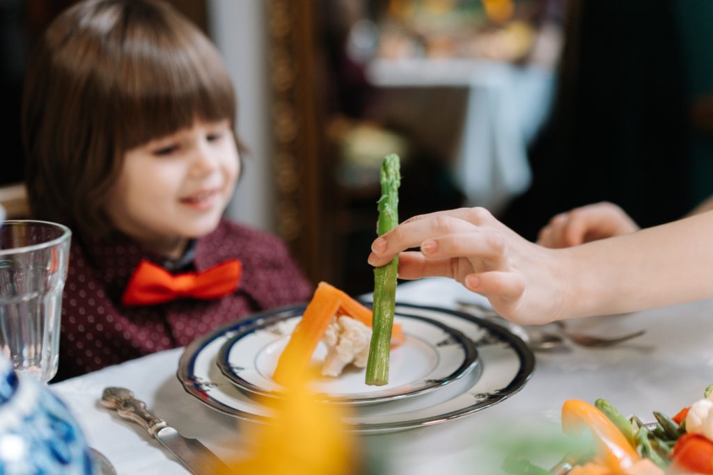 petit garçon regarde son assiette : asperge et maison en aliments 