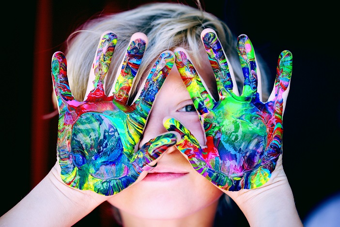 Un enfant a plein de peinture sur les mains