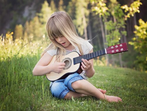 Une petite fille joue à la guitare