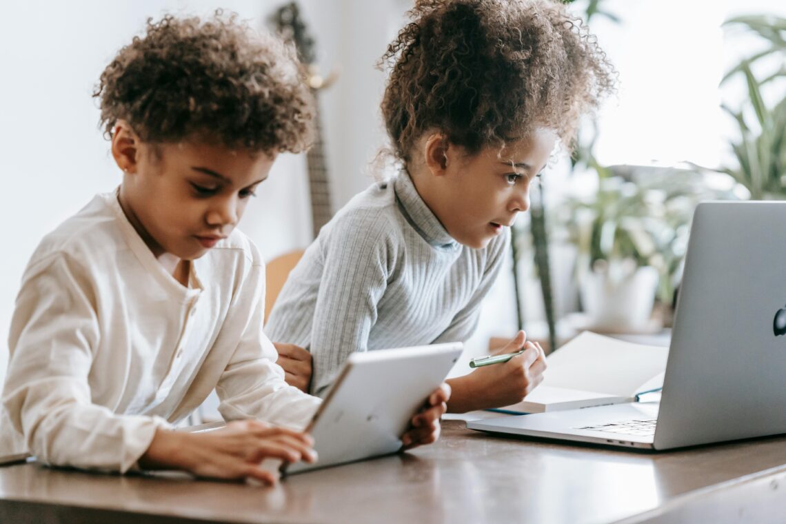 2 enfants sont devant des écrans