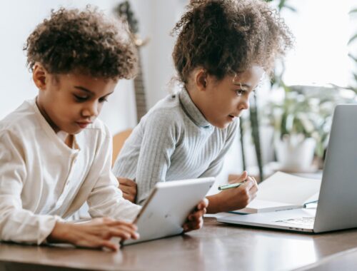 2 enfants sont devant des écrans