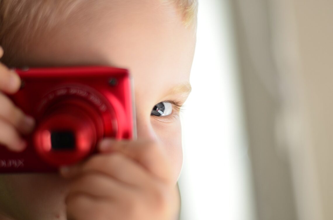 Un petit garçon joue avec son appareil photo