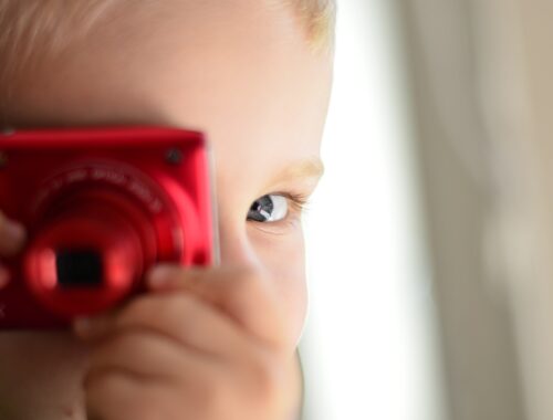 Un petit garçon joue avec son appareil photo