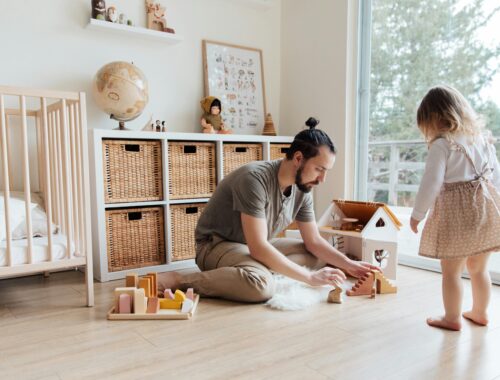 Une petite fille et son papa jouent dans sa chambre