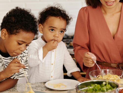 Une maman et ses deux enfants partagent un moment autour de l'assiette