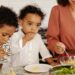 Une maman et ses deux enfants partagent un moment autour de l'assiette