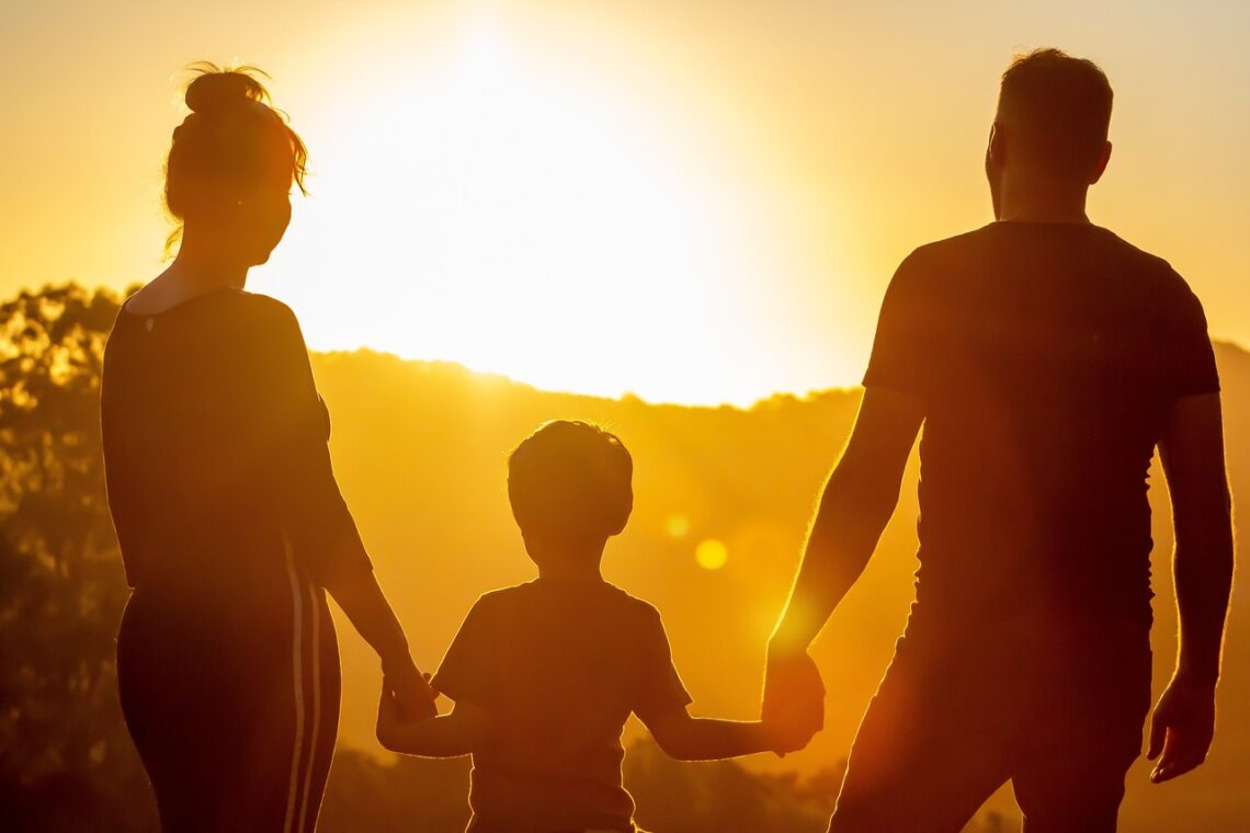 Une famille devant un couché du soleil