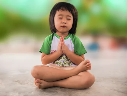 Un petit garçon est assis en position de méditation