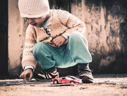 Un enfant joue avec des petites voitures