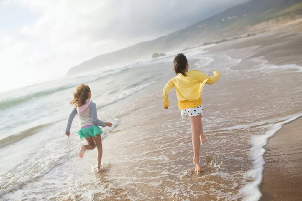 Deux petites filles courent dans le sable