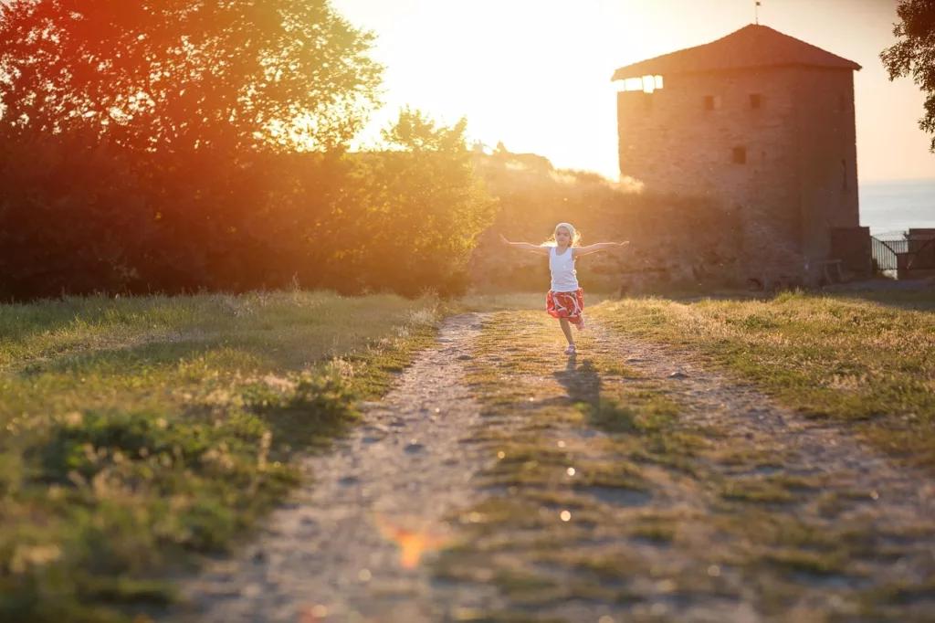 Une petite fille courre dans un pré.