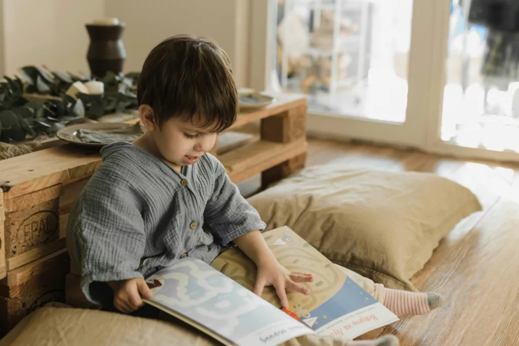 Un petit garçon s'est installé dans un coin pour lire un livre