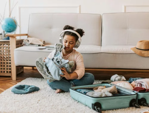 Une petite fille écoute un podcast tout en faisant sa valise