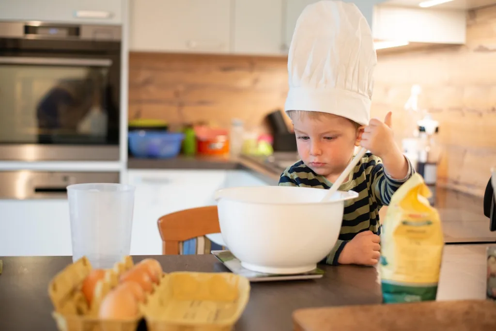 Un petit garçon prépare un gâteau