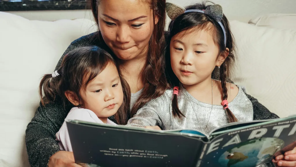 Parent lisant un livre avec ses enfants dans le salon
