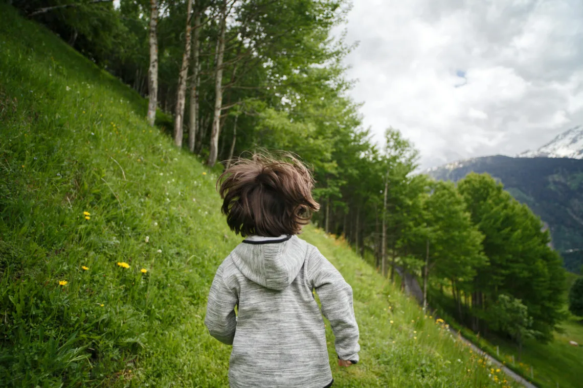 Un petit garçon court dans la montagne