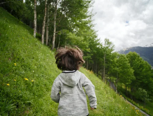 Un petit garçon court dans la montagne