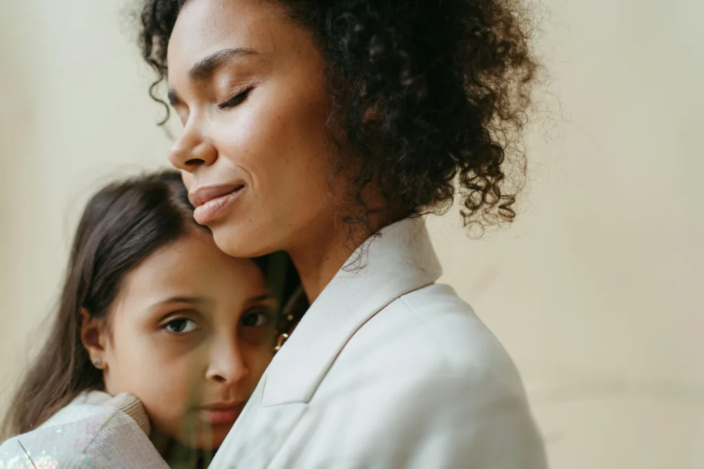 Une maman et sa fille font un câlin